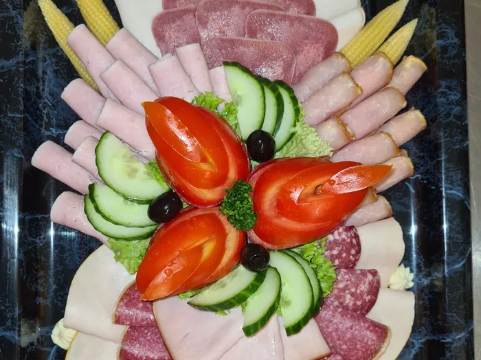 Fertig belegte Aufschnittplatte mit Schinken, Salami und Gemüsegarnitur