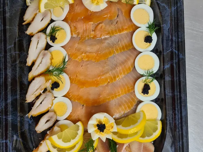 Fischplatte mit geräuchertem Lachs, Forellenfilet, Eiern, Kaviar und Zitrone