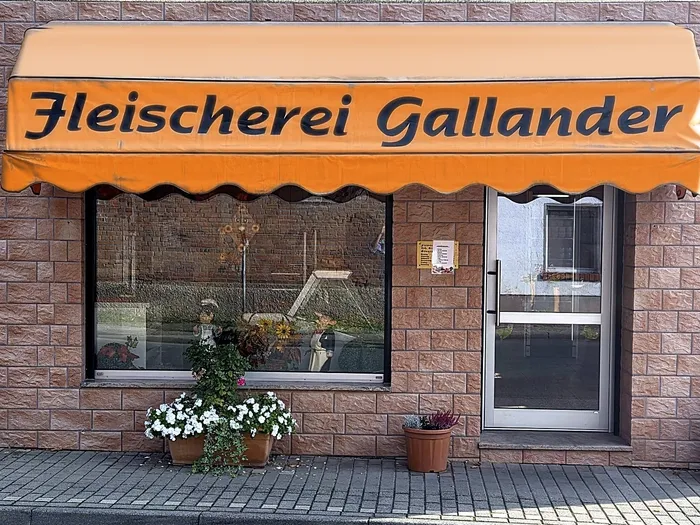 Ladengeschäft der Fleischerei Gallander in Weißenfels-Langendorf mit Markise und Blumen vor dem Schaufenster